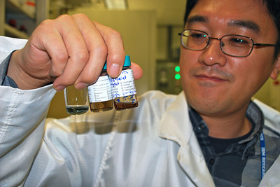 IBM researcher Hongsik Park observes different solutions of carbon nanotubes. Carbon nanotubes, borne out of chemistry, have largely been laboratory curiosities as far as microelectronic applications are concerned. Carbon nanotubes naturally come as a mix of metallic and semiconducting species and need to be placed perfectly on the wafer surface to make electronic circuits. For device operation, only the semiconducting kind of tubes is useful which requires essentially complete removal of the metallic ones to prevent errors in circuits. (Photo credit: IBM)